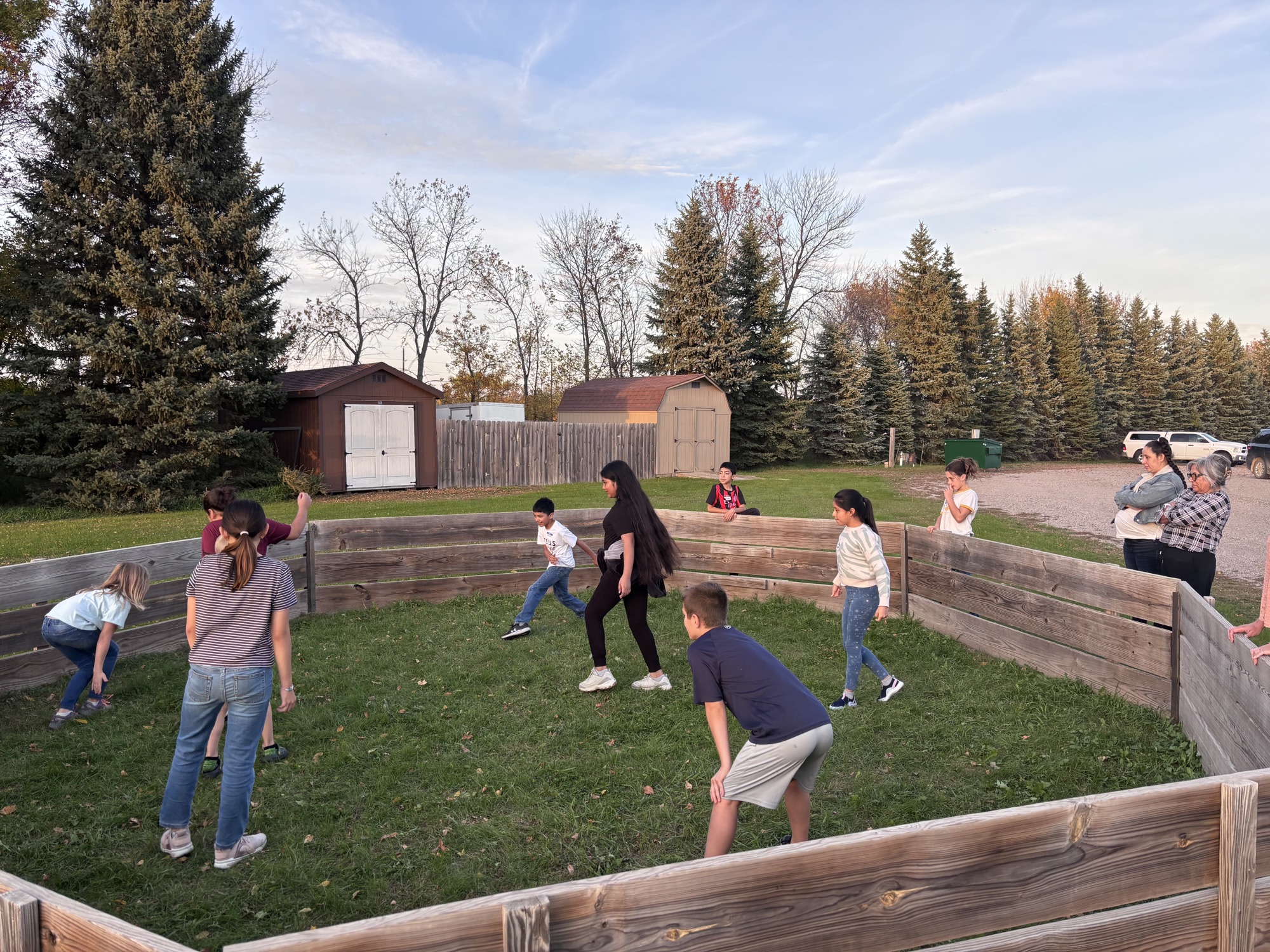 Kids playing gaga ball outside at sunset